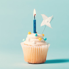 Cupcake with candle celebration theme on a blue background