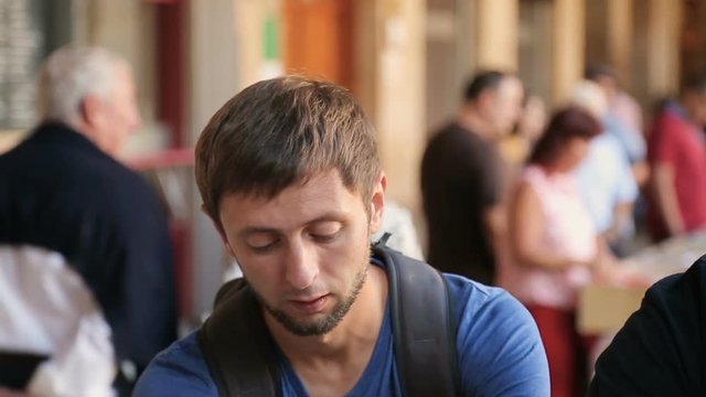Young man choosing vinyl record out of music collection at local flea market