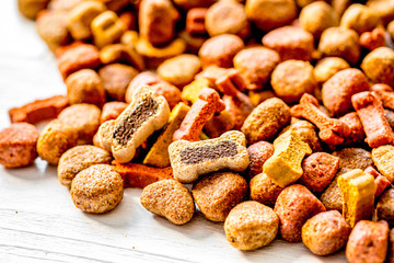 dry dog food in bulk on wooden background close up