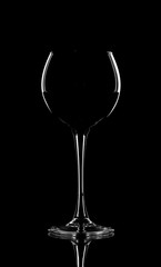 Red wine pouring in wineglass from bottle over black background. Wine list design menu with copyspace. Alcohol beverage card backdrop.