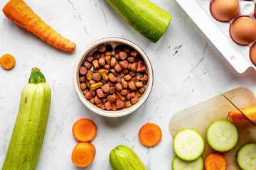 Vegetables and petfood on kitchen table background top view