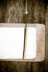 Butter on a wooden chopping board  cut with a knife