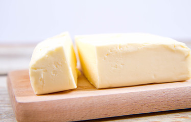 Butter on a wooden chopping board  cut with a knife