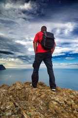 Man on the mountain edge. Tourist on the mountain edge