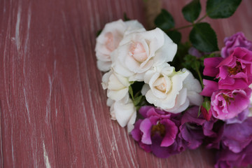 Bouquet of pink and purple garden roses on a wooden background