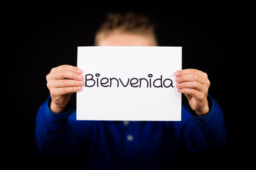 Child holding sign with Spanish word Bienvenida - Welcome