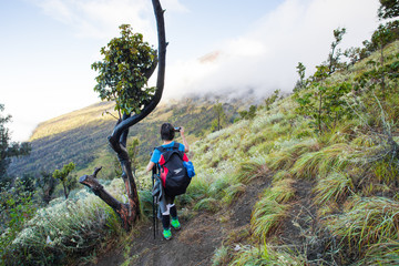 Naklejka na ściany i meble Asian traveling backpacker in volcano mountain Rinjani of Indonesia.