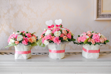 Flower table decorations for a wedding party. The bouquets from pink and white roses.