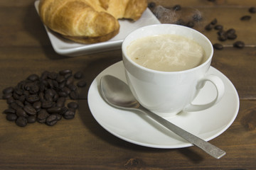 coffee and croissant on wooden