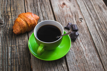 Breakfast with coffee and croissants on wooden vintage table