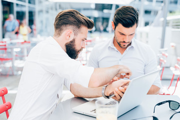 Obraz premium two bearded business men young outdoor using smart phone - wifi technology, social network, multitasking concept