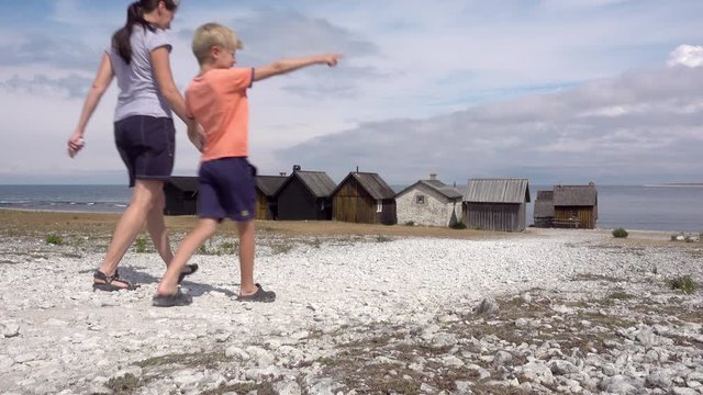 A mother and her son walking by the fishing hamlet Helgumannen on the island Faro, Gotland, Sweden.