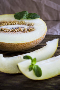 Two slices of melon and a half of fruit with seeds inside