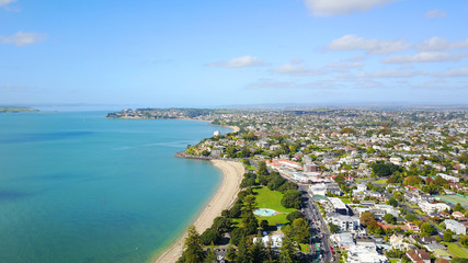 Fototapeta na wymiar Aerial view on sunny beach with residential suburb on the background. Auckland, New Zealand.