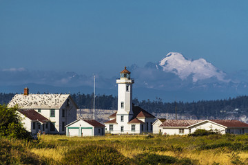 Fototapeta na wymiar pacific northwest lighthouse with mountain in the background 