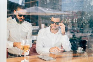two bearded business men young outdoor view through a window bar - business, break, remote working concept