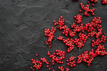 Berry theme. Red currant on black table background top view copyspace