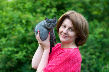 woman is holding a thoroughbred kitten. Scottish Straight