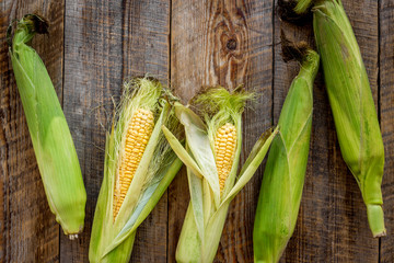 Fresh corn on rustic wooden table top view copyspace