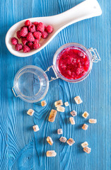 Homemade natural jam. Berries and sugar on blue wooden and canvas background top view