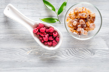 Making raspberry jam. Berries and sugar on grey wooden background top view copyspace
