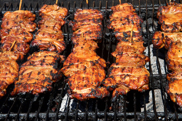 Chicken filets on a wooden stick, grilling on a BBQ open to the air