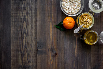 Sweet summer breakfast. Oatmeal, oranges, honey, sugar on wooden table background top view copyspace