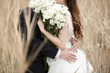 Couple holding hand with flower in wedding day photo shoot before married