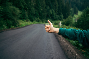 Hand of hiker woman at rural mountain road.