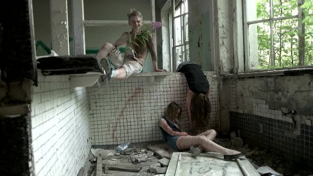 Maniac throws a flower at the dead girls and laughs