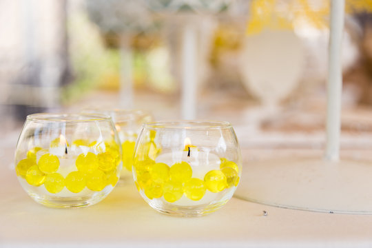 Candele decorate con sfere di vetro gialle in ampolle di vetro