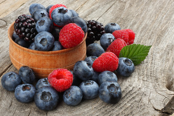 mix of blueberries, blackberries, raspberries on old wooden table background
