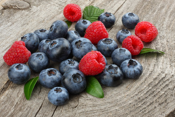 mix of blueberries, blackberries, raspberries on old wooden table background
