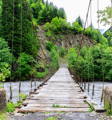 Road Suspension bridge over a mountain river during a rain in Georgia