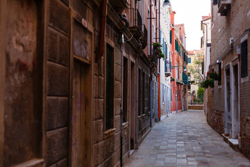 view of a small narrow street situated in a less visited part of italian city venice