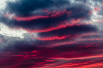 mysterious fiery sky with altocumulus clouds at sunset