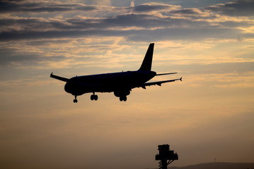 Airplane landing at sunset