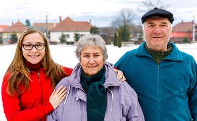 Happy elderly couple and young caregiver