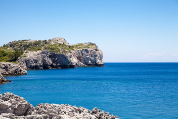 Obraz premium Beach off the coast of the island of Rhodes in Faliraki, Greece. Seaside landscape. Rocky coast and sea.
