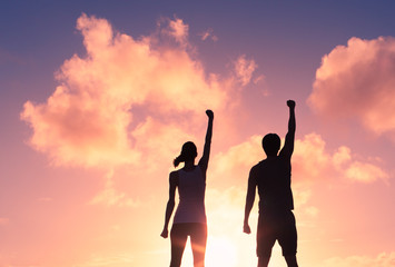 Fototapeta premium People, power, and victory. Silhouette of confident man and woman with fist in the air.