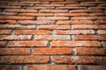 Obraz premium Red brick wall texture grunge background with vignetted corners in perspective view. Selective focus