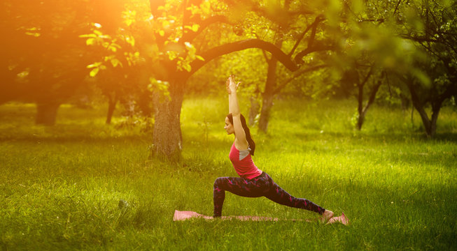 Woman practicing high lunge yoga pose. Young female exercising outdoors. Utthita Ashwa Sanchalanasana. Toned image.