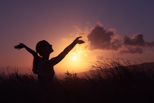 Young woman feeling happy and free in a beautiful, sunset nature setting. 