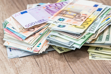 Pile money: dollars and euros banknotes on desk