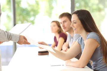 Student receiving an exam from the teacher