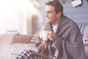 Smiling man warming himself with tea