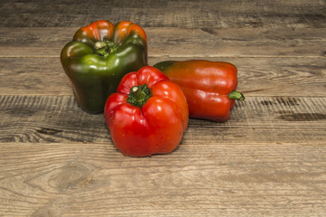 A few peppers on a wooden table