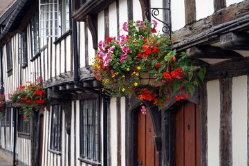 Traditional tudor timber framed wattle and daub houses with pretty hanging baskets