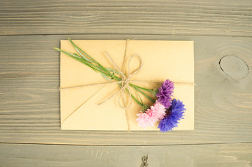 envelope with flowers on wooden background