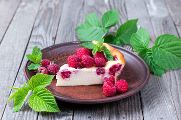 A slice of cheesecake with raspberries